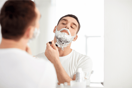 man shaving in mirror